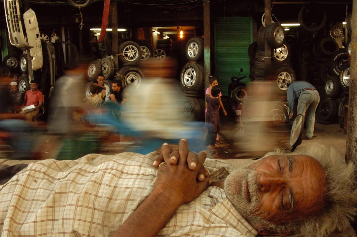 Un laboureur fait la sieste sur un marché animé, Chawri Bazar, Delhi, Raghu Rai, 2005.